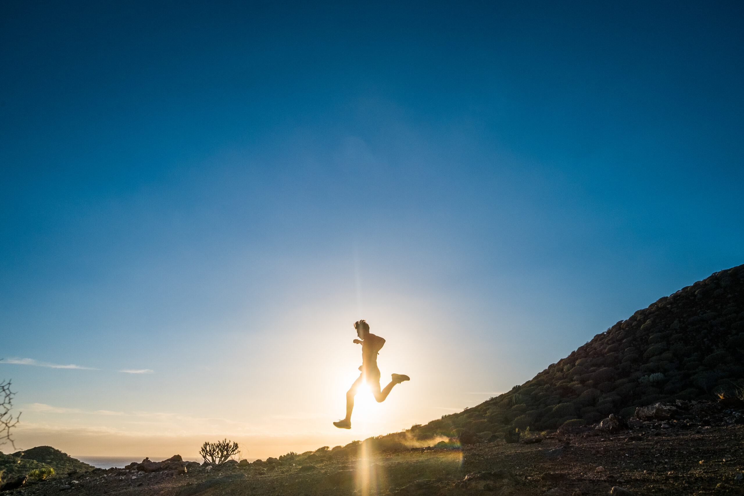 one young man running alone in the mountain at the sunset to be fitness and have an healthy lifestyle doing jogging